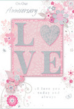 In this image, an anniversary card lies neatly arranged, its romantic design recalling the elegant, pastel-toned arrangements often delivered around West Hampstead. The central focus is the word LOVE, written in bold, uppercase letters that are slightly raised, each form coated in a soft blend of blush-pink and pearly white glitter. The glitter appears finely milled, giving a refined sparkle that catches the light in a gentle, almost candle-like way. Around this central word, a constellation of delicately drawn flowers, leaves, and tendrils curls across the card, creating a sense of movement and lightness. The illustrated blooms are rendered in shades of blush, mauve, and ivory, anchored with quiet touches of soft grey and silver that recall the subtle gleam of ribbon or foil used in a florist's wrapping. Their loose, flowing placement feels similar to the natural style of a hand-tied bouquet destined for a home off Finchley Road or a cosy flat near Fortune Green. The background is a smooth expanse of powder-pink, subtly shaded to give the impression of depth without distracting from the floral artwork. Light falls evenly across the surface, illuminating the raised glitter and metallic accents so they glow softly. Graceful script phrases - including On Our Anniversary and I love you today and always - are set among the illustrations in an elegant, looping font, their rhythm echoing the curves of the vines and petals. Small flourishes - tiny petals, gentle swirls, and almost-suggested butterflies - lend a whisper of whimsy, as if a soft breeze from Hampstead Heath had brushed the design. The overall feeling is one of treasured intimacy and enduring affection, like a paper bouquet chosen to accompany fresh anniversary flowers delivered with care throughout West Hampstead.